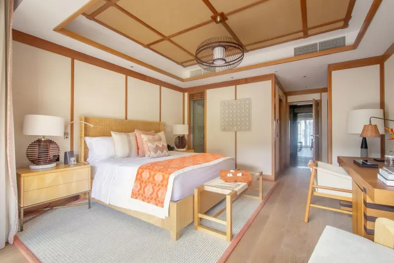 Une chambre lumineuse avec un grand lit et un bureau.