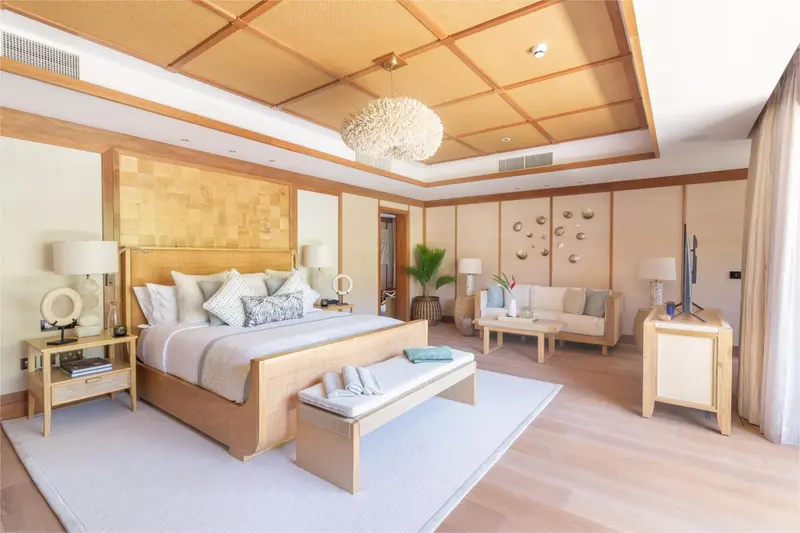Une chambre lumineuse avec un grand lit et un coin salon.