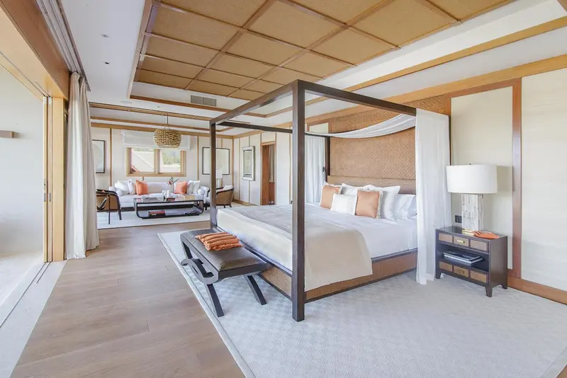 Une chambre spacieuse avec un lit à baldaquin et un coin salon.