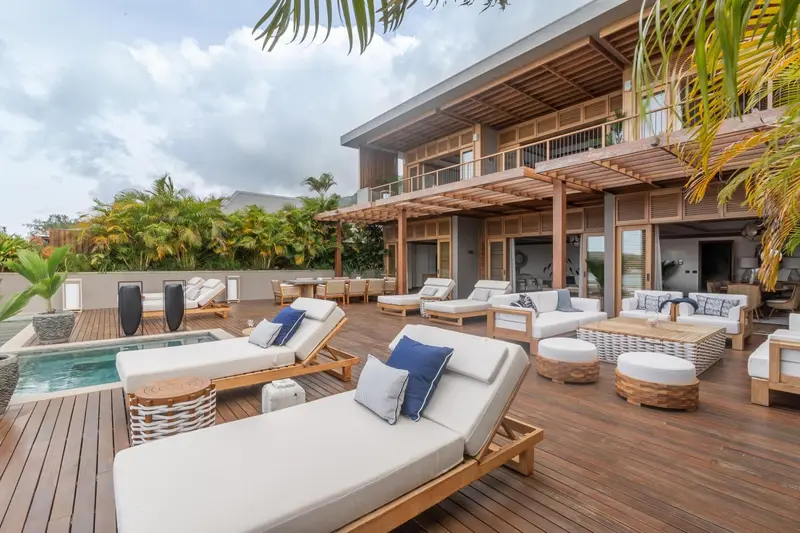 Terrasse en bois avec transats et mobilier de détente.