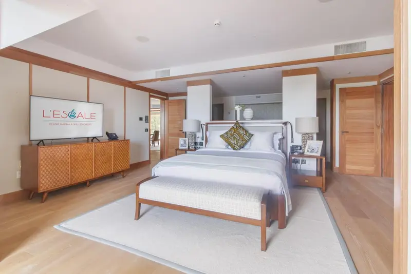 Une chambre lumineuse avec un grand lit et un coin salon.