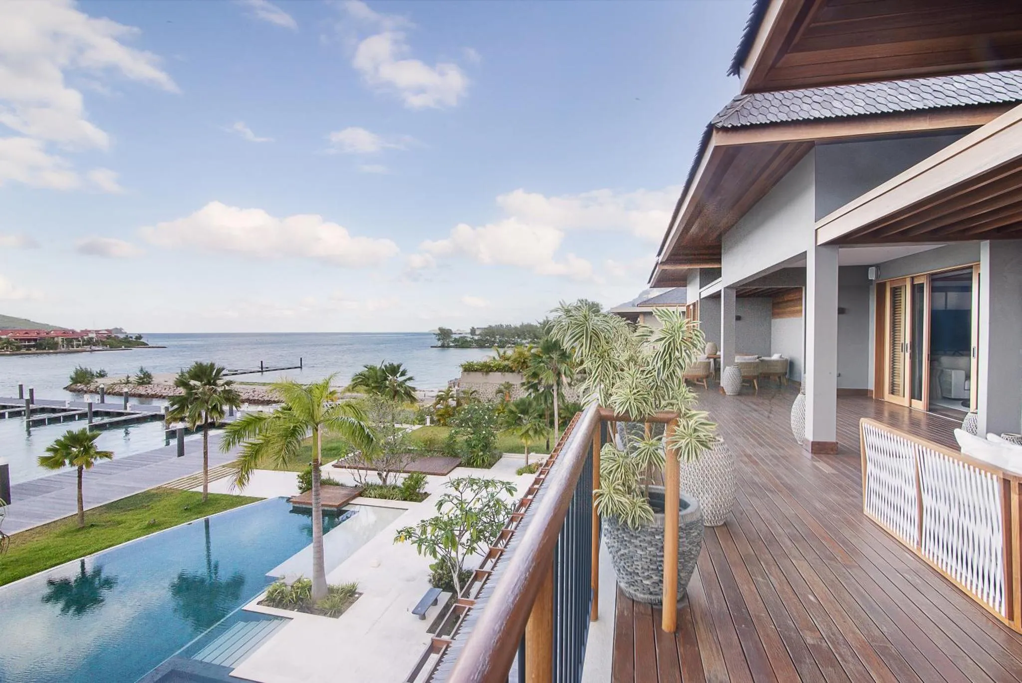 Terrasse en bois avec vue sur la mer et une piscine.