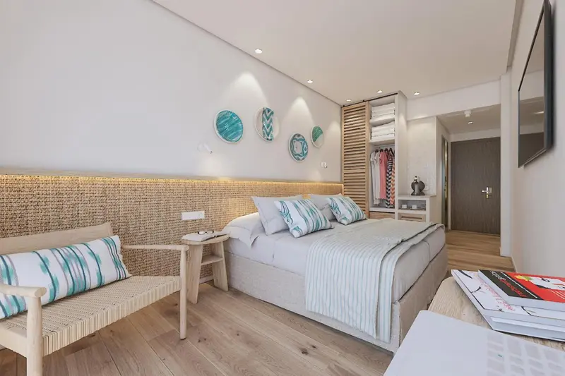Chambre lumineuse avec un grand lit et une décoration murale.