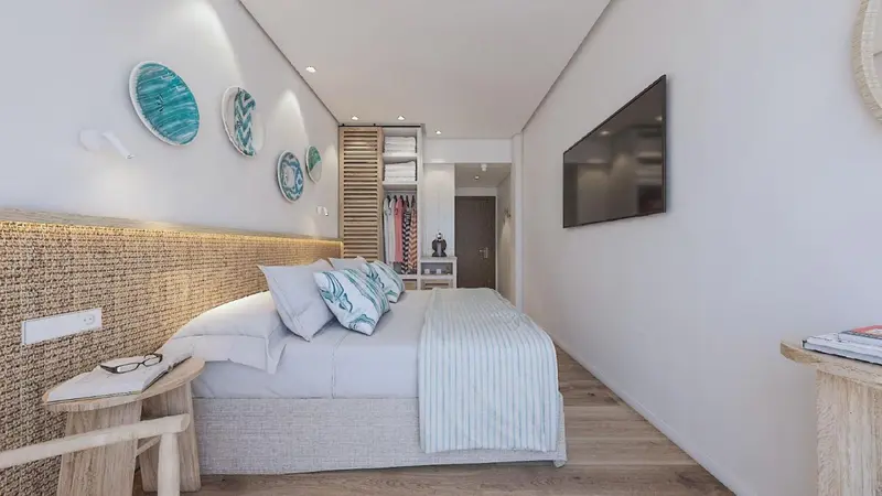 Une chambre lumineuse avec un grand lit et une décoration murale colorée.