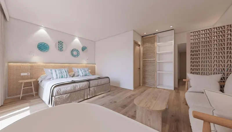 Chambre lumineuse avec un grand lit et un coin salon.