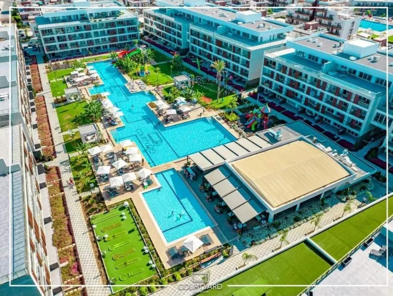 Vue aérienne d'un complexe hôtelier avec piscine et espaces de détente.