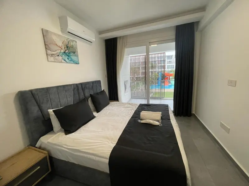 Une chambre lumineuse avec un grand lit et un accès à une terrasse.