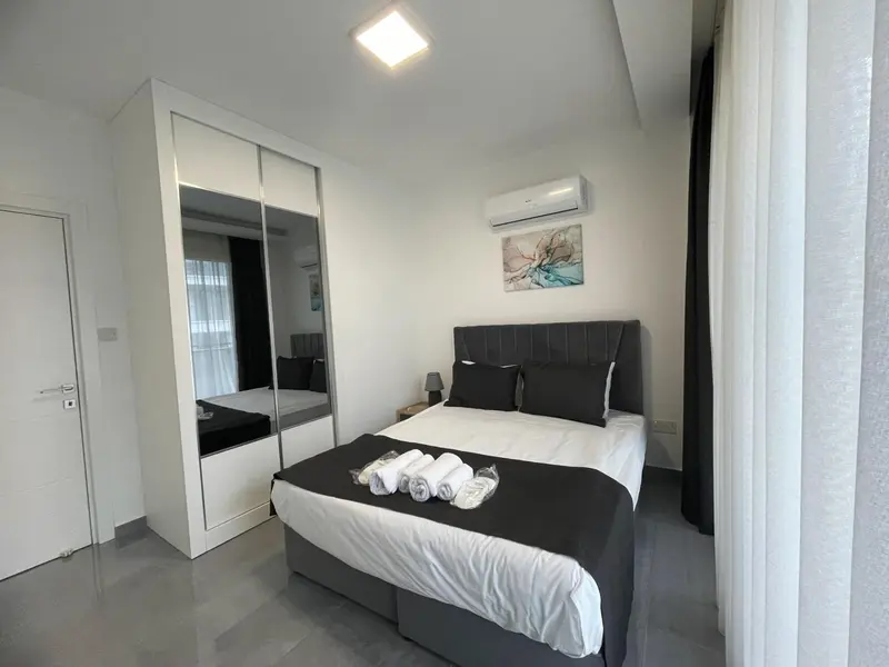 Une chambre moderne avec un grand lit et une armoire.