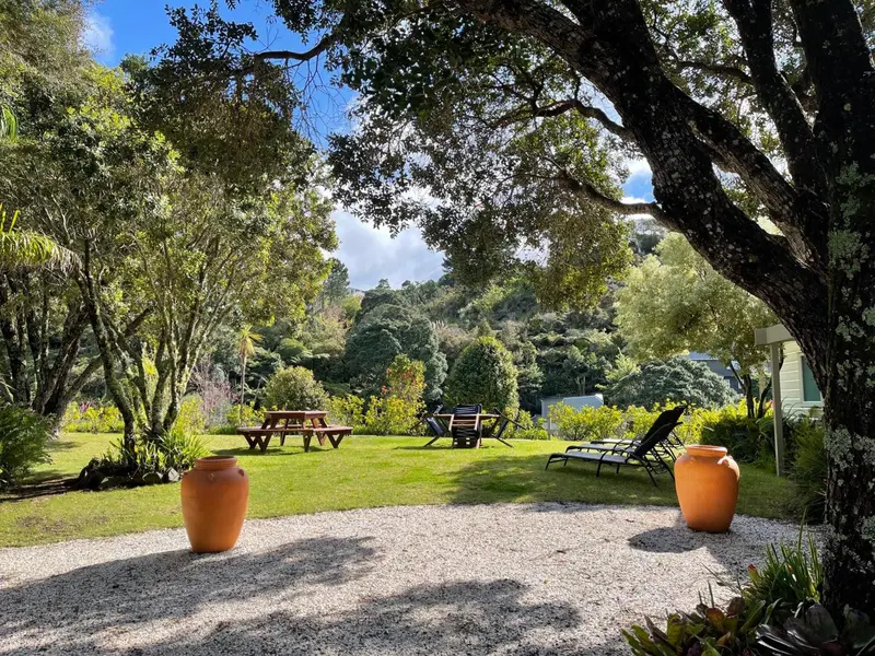 Un jardin verdoyant avec des tables de pique-nique et des chaises longues.