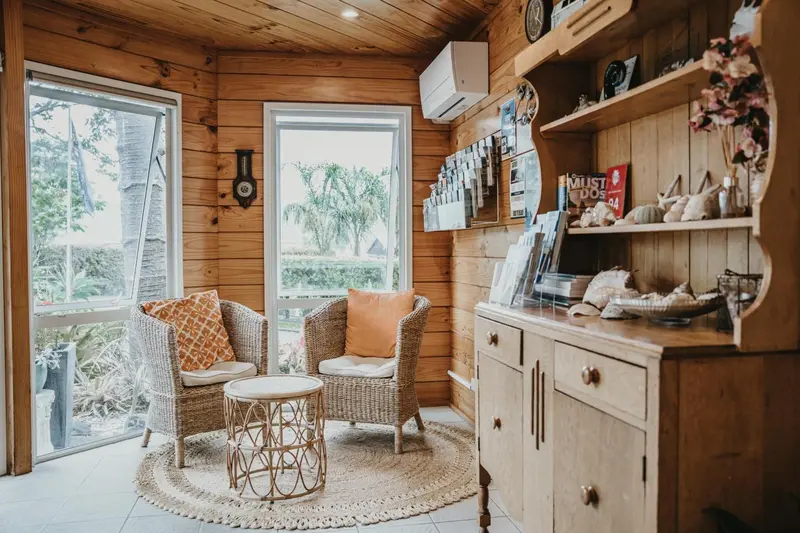 Espace de détente intérieur avec mobilier en rotin et décoration florale.