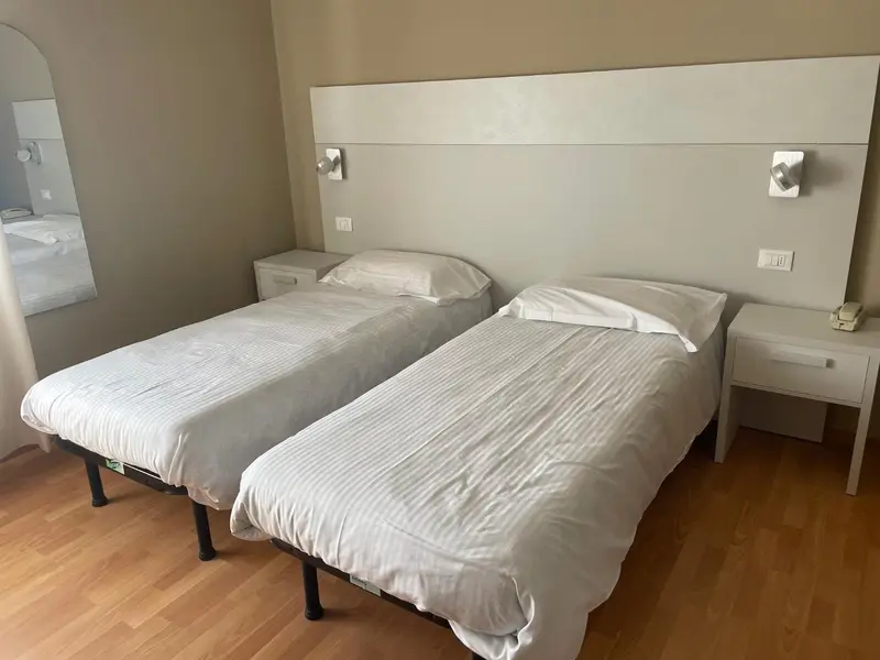 Deux lits simples dans une chambre lumineuse.