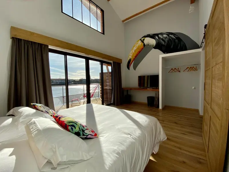 Une chambre lumineuse avec un grand lit et une vue sur l'eau.