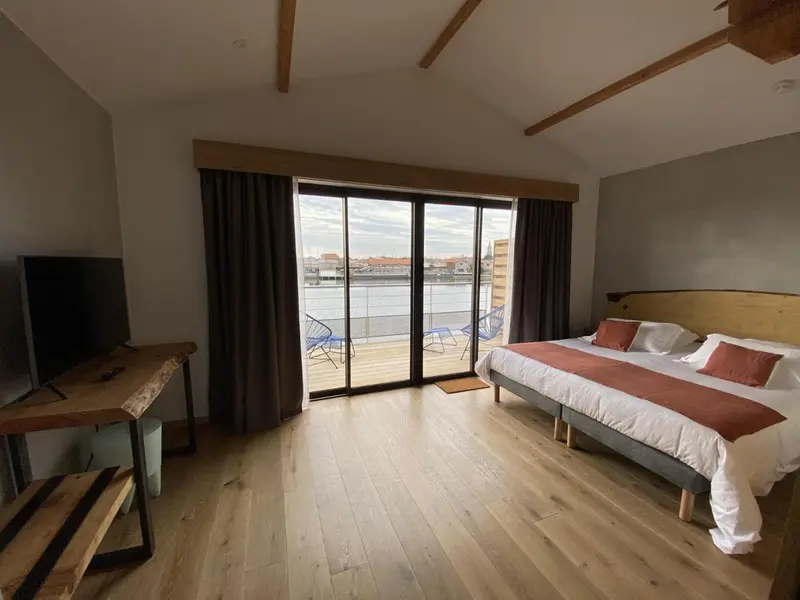 Une chambre lumineuse avec un grand lit et un accès à une terrasse.