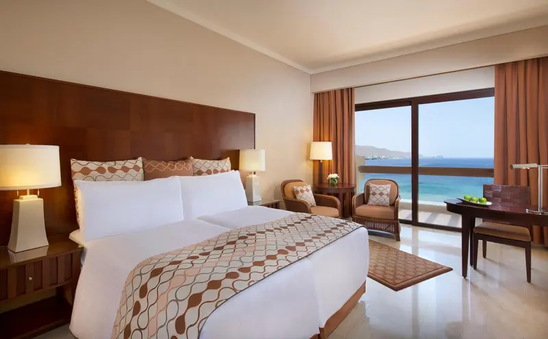 Une chambre lumineuse avec un grand lit et une vue sur la mer.