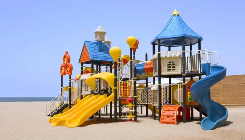 Structure de jeux colorée sur une plage de sable.
