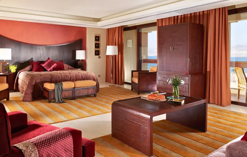Chambre spacieuse avec un grand lit et un coin salon.