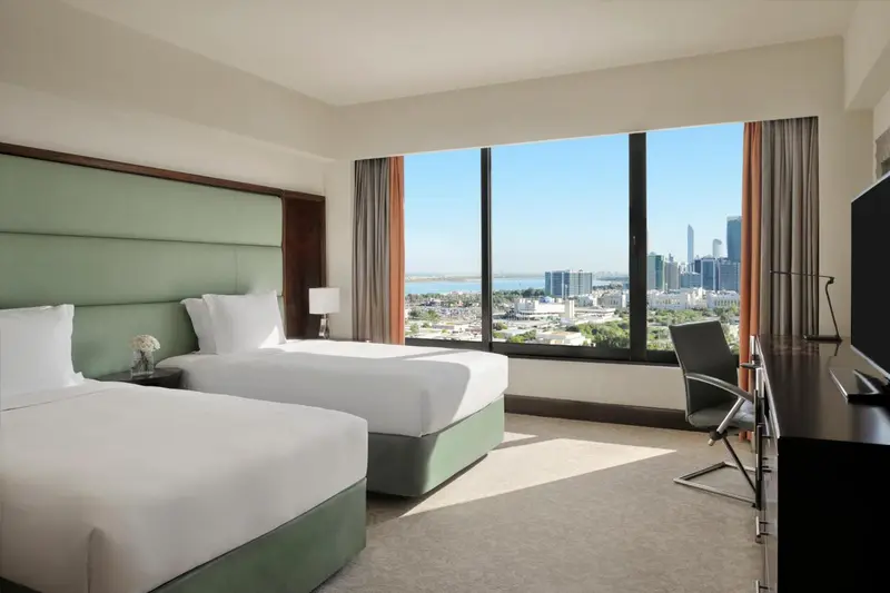 Chambre d'hôtel avec deux lits et vue sur la ville.
