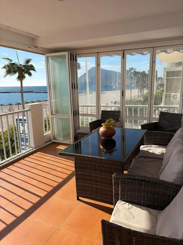 Terrasse avec mobilier en résine tressée et vue sur la mer.