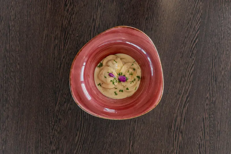 Un plat de champignons à la crème est présenté dans un bol rouge.