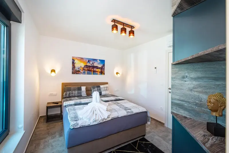 Chambre moderne avec un grand lit et une décoration murale.