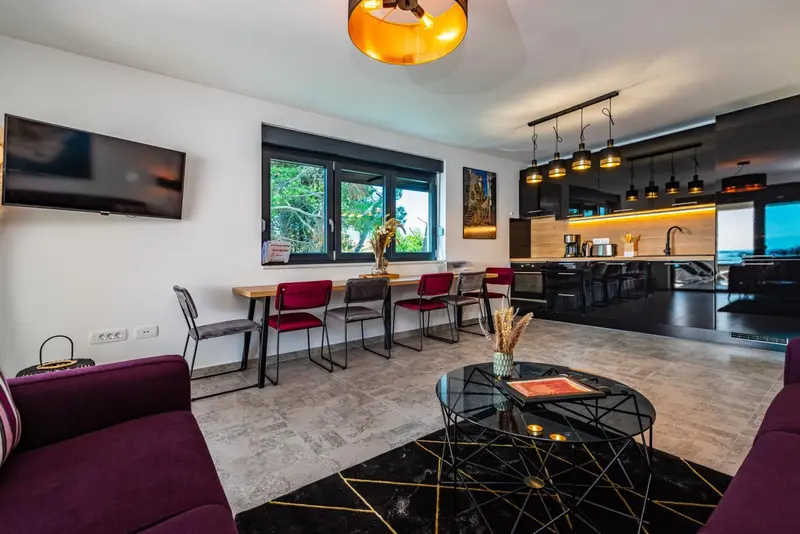 Espace de vie moderne avec coin repas et cuisine ouverte.