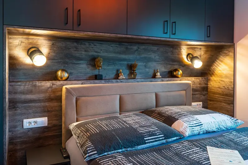 Une chambre à coucher avec un grand lit et une décoration murale en bois.