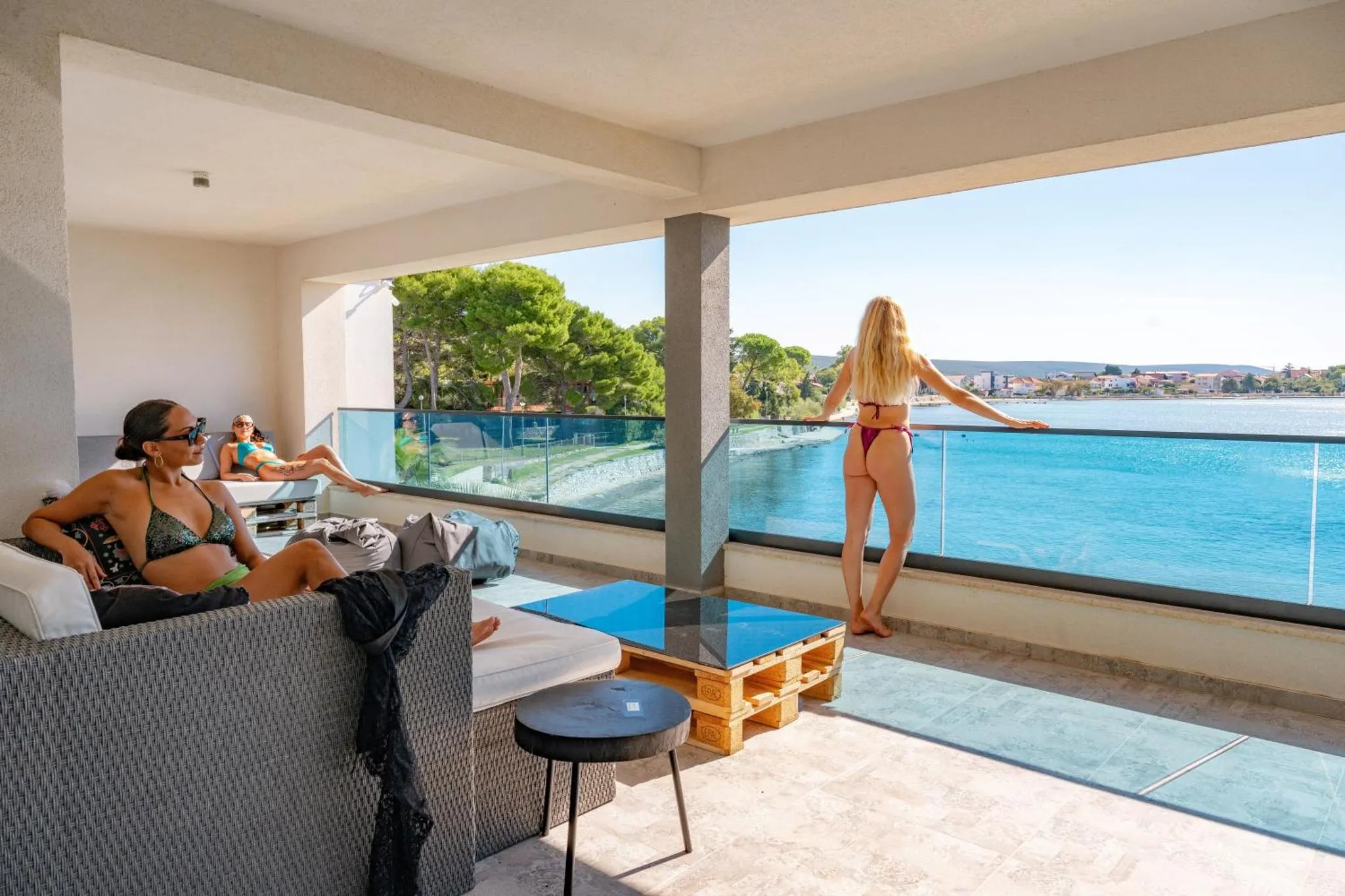 Deux femmes se détendent sur une terrasse avec vue sur la mer.