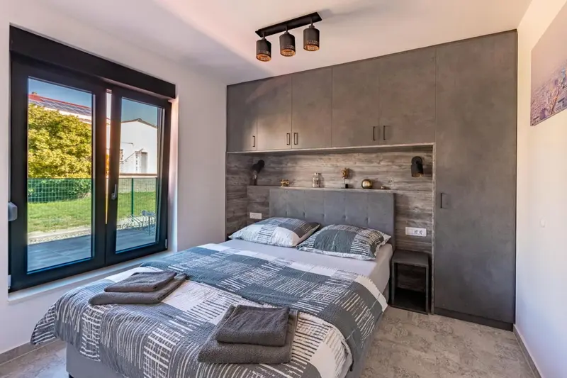 Une chambre moderne avec un grand lit et un mur texturé.