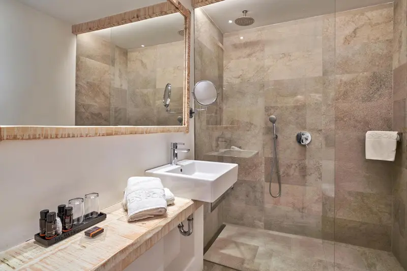 Une salle de bain moderne avec douche à l'italienne et vasque.