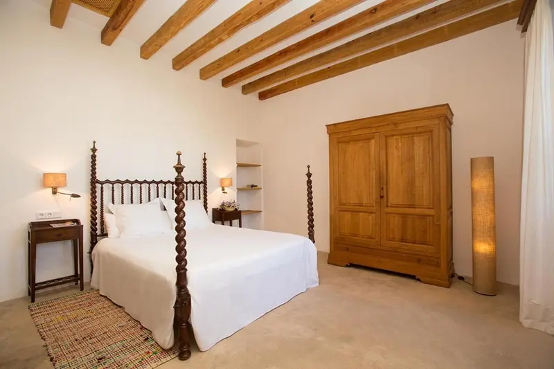 Une chambre lumineuse avec un lit à baldaquin et un grand placard en bois.