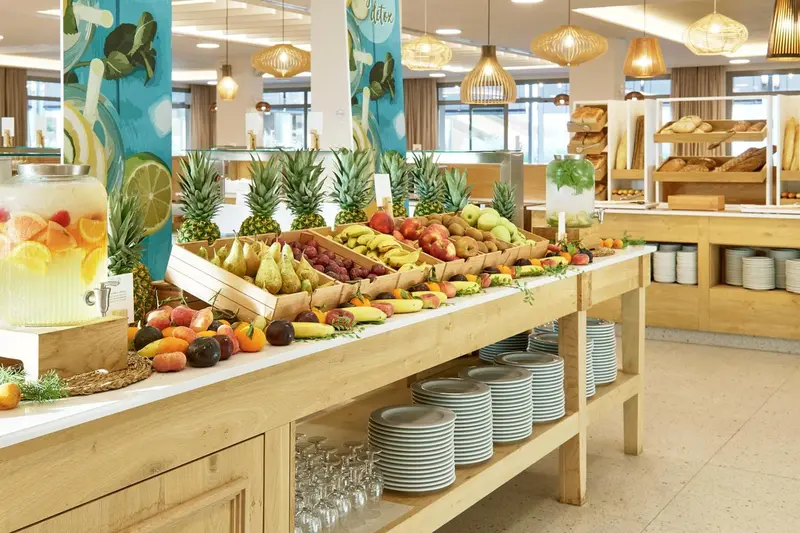 Un buffet propose une grande variété de fruits frais et de pâtisseries.