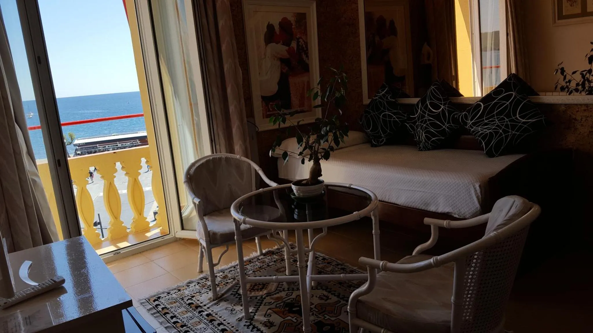 Espace de détente lumineux avec mobilier blanc et vue sur la mer.