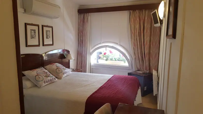 Une chambre lumineuse avec un lit double et une fenêtre en ogive.