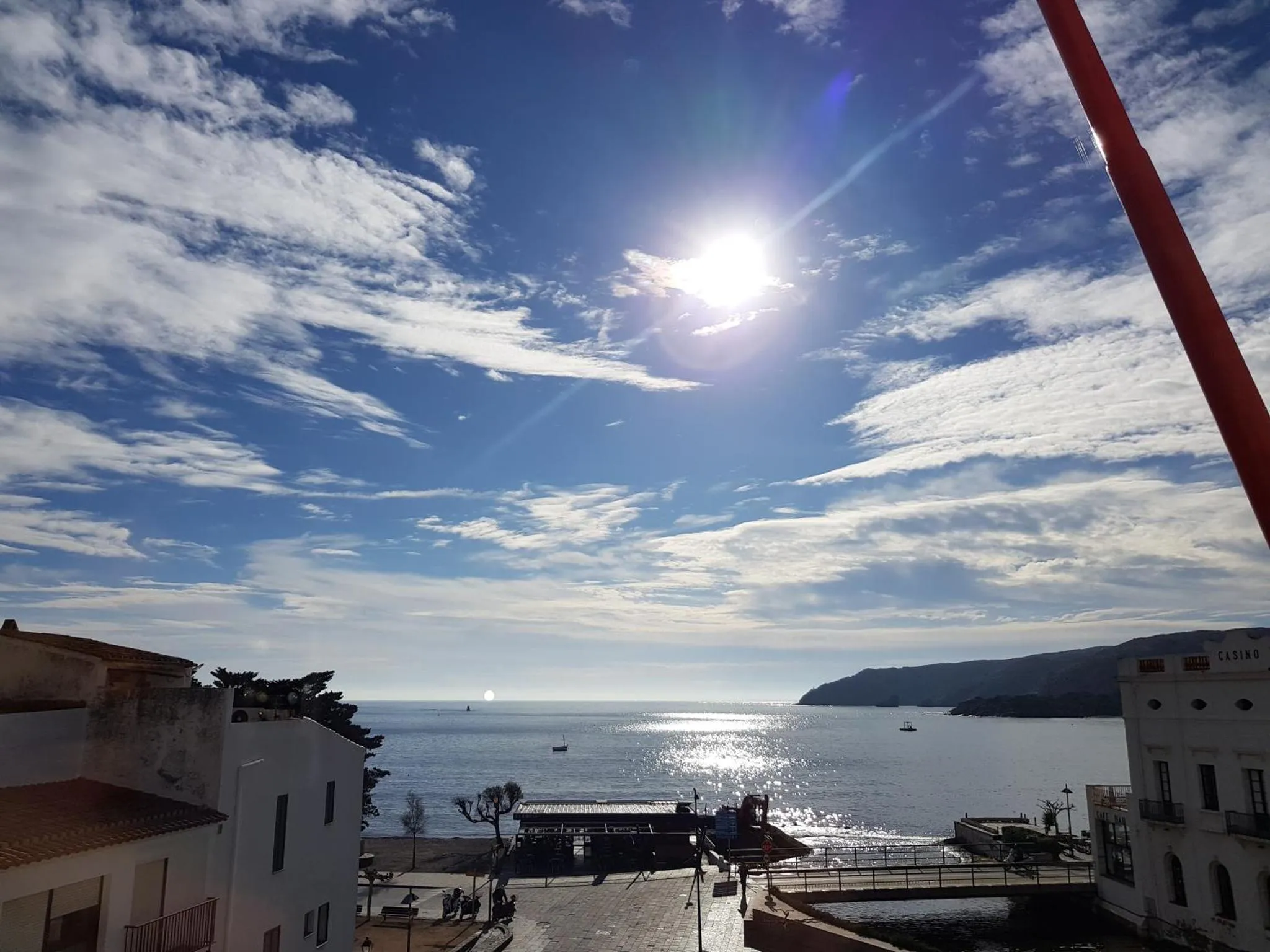 Vue sur la mer depuis une terrasse ensoleillée.