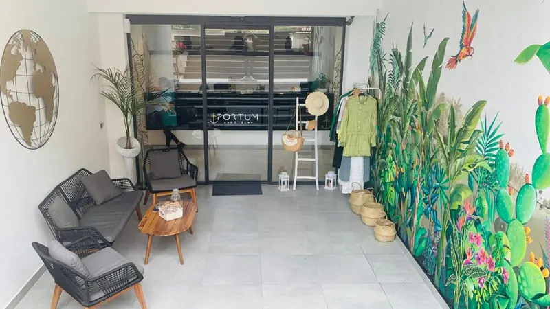 Espace d'attente lumineux avec canapés et décoration tropicale.