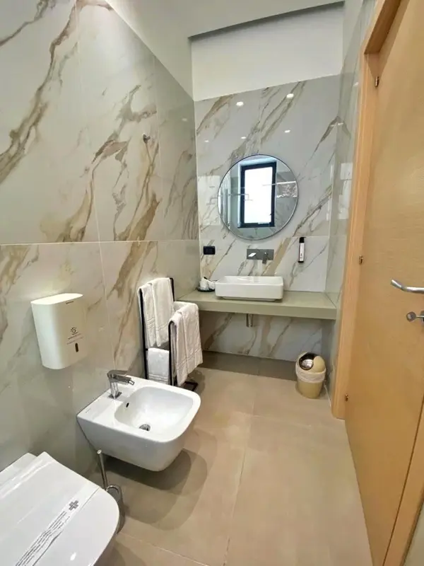 Une salle de bain moderne avec des carreaux marbrés et un lavabo.
