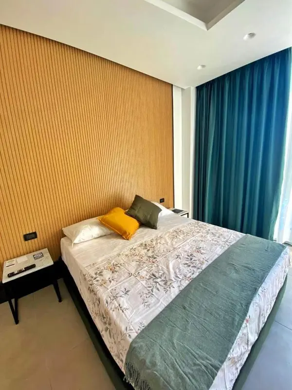 Un lit recouvert d'une couette et d'oreillers dans une chambre décorée de bois et de rideaux.