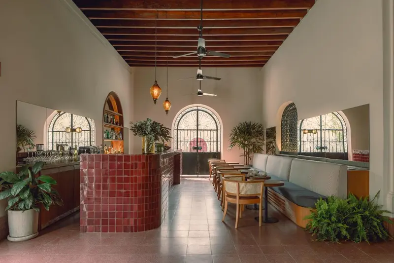 Une salle lumineuse avec un comptoir de bar et des banquettes le long des murs.