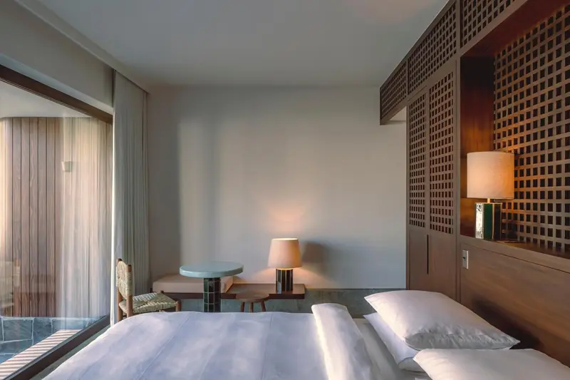 Une chambre lumineuse avec un lit et une table de chevet.