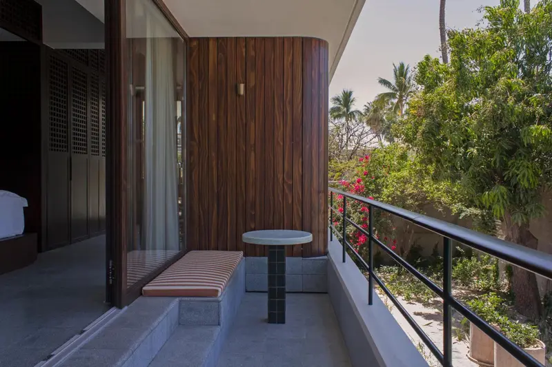 Une terrasse avec une table ronde et un banc intégré offre une vue sur la végétation luxuriante.
