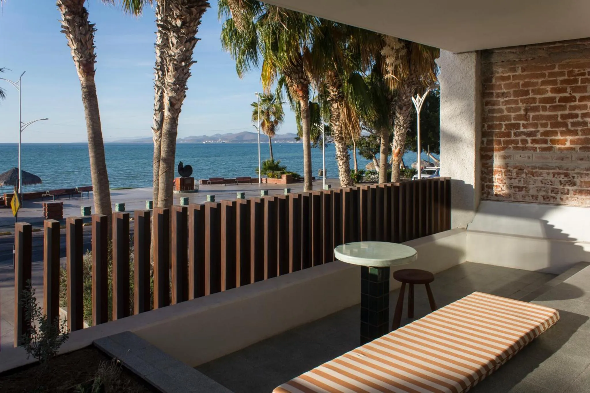 Terrasse avec mobilier d'extérieur donnant sur la mer et la promenade.