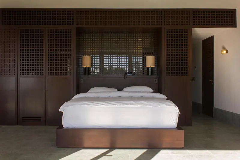 Une chambre lumineuse avec un grand lit recouvert de draps blancs.