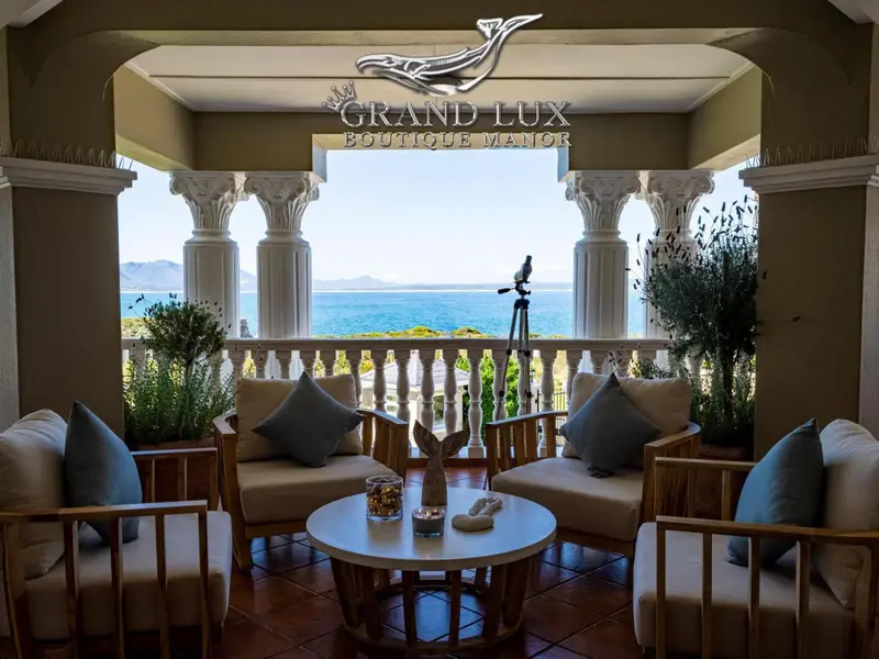 Espace de détente extérieur avec mobilier en bois et vue sur la mer.