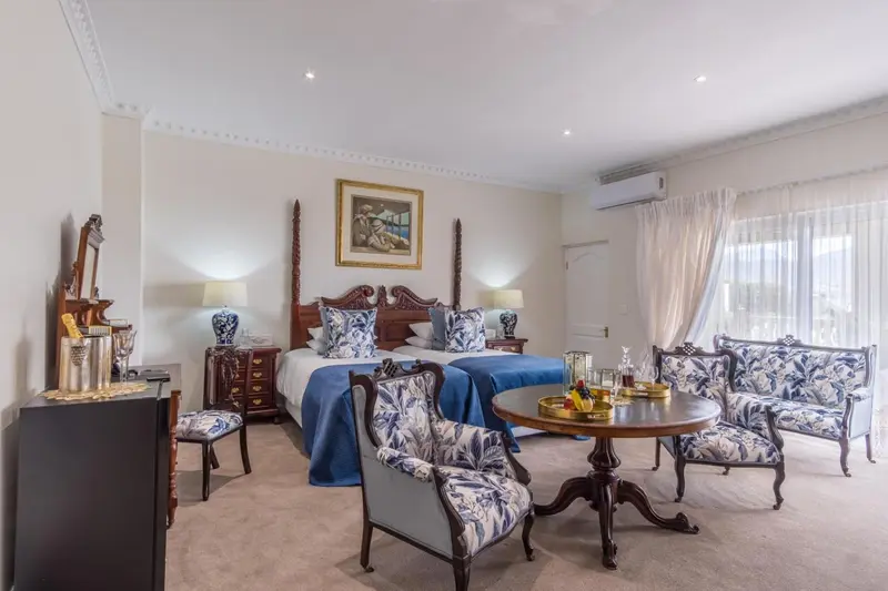 Une chambre lumineuse avec un grand lit et un coin salon.