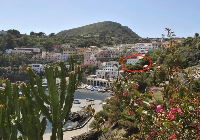 Vue d'un village coloré sur une colline surplombant un port de plaisance.