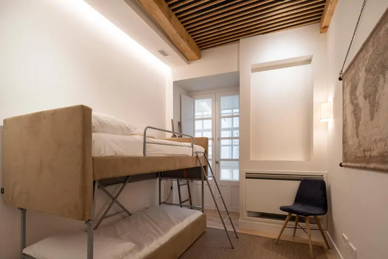 Une chambre avec un lit superposé près d'une fenêtre.