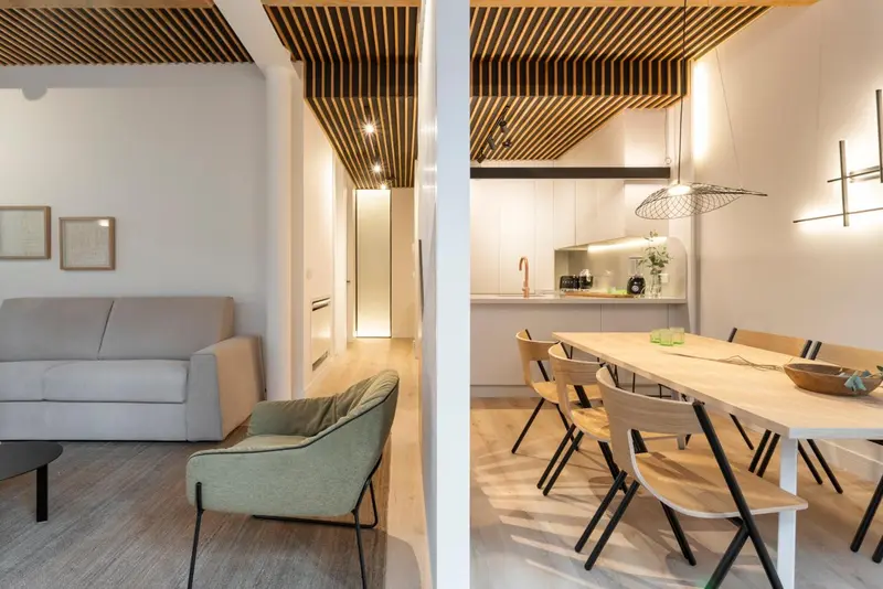 Espace de vie lumineux avec canapé, table à manger et cuisine ouverte.