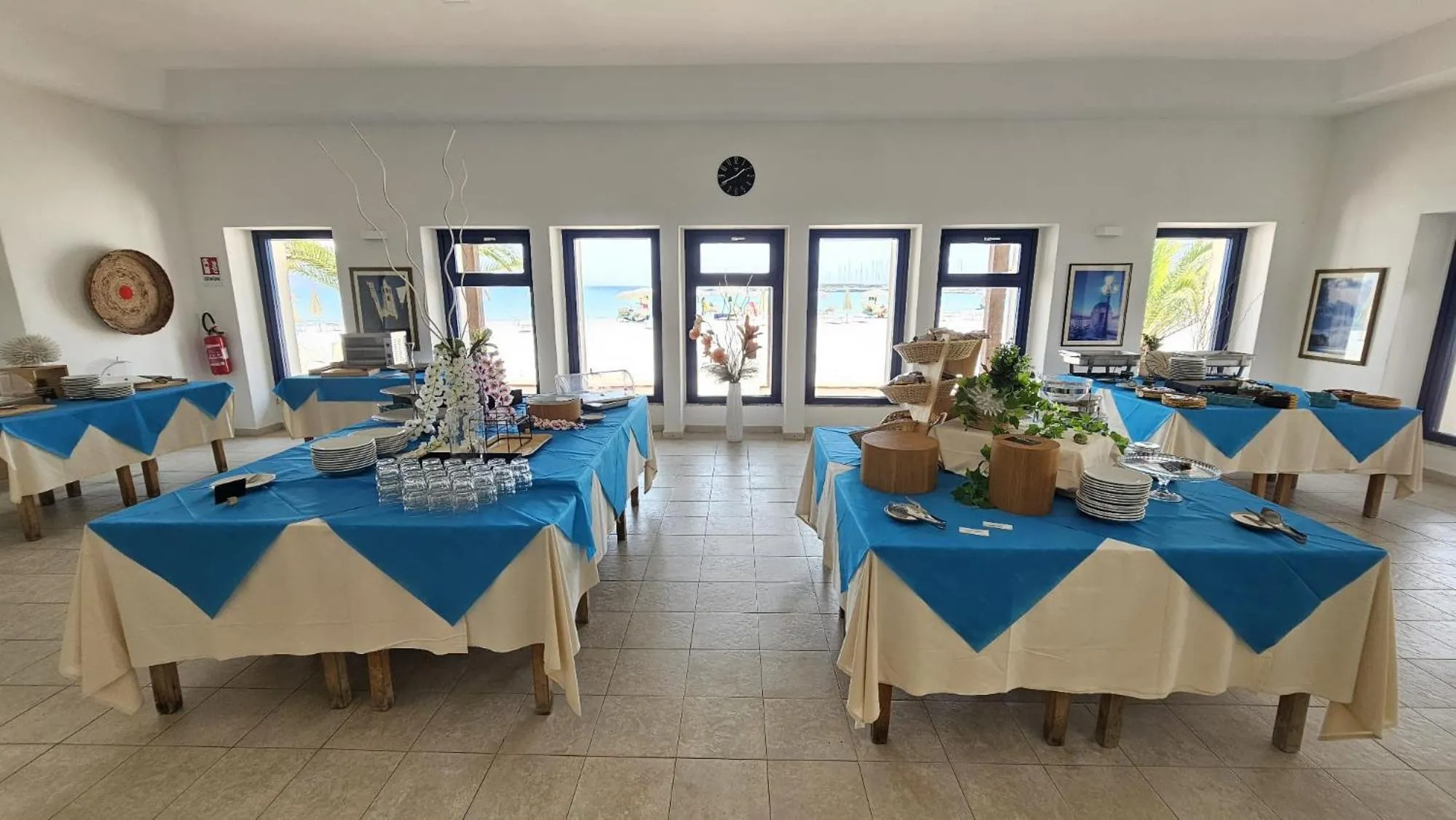 Une salle lumineuse avec des tables dressées pour un buffet.