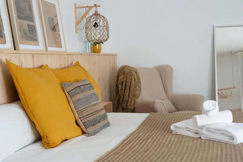 Un lit avec des oreillers colorés dans une chambre lumineuse.