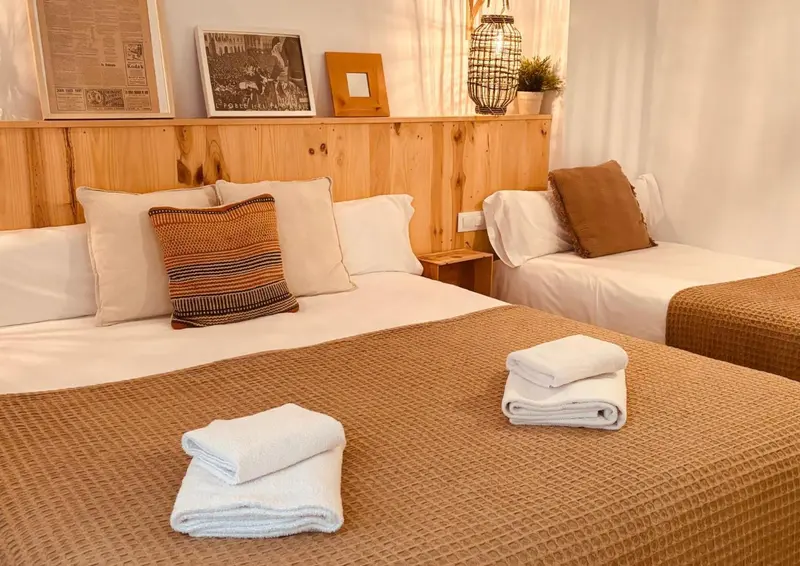 Une chambre avec deux lits simples et une décoration murale en bois.